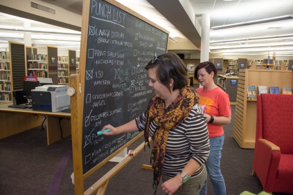 Julia McConnell, left, and Angel Suhrstedt check off the punch list before Monday's opening of the Edmond Public Library.