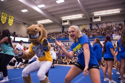 Kendall McDaniel, a cheerleader with the University of Central Oklahoma, dances with the school's mascot.